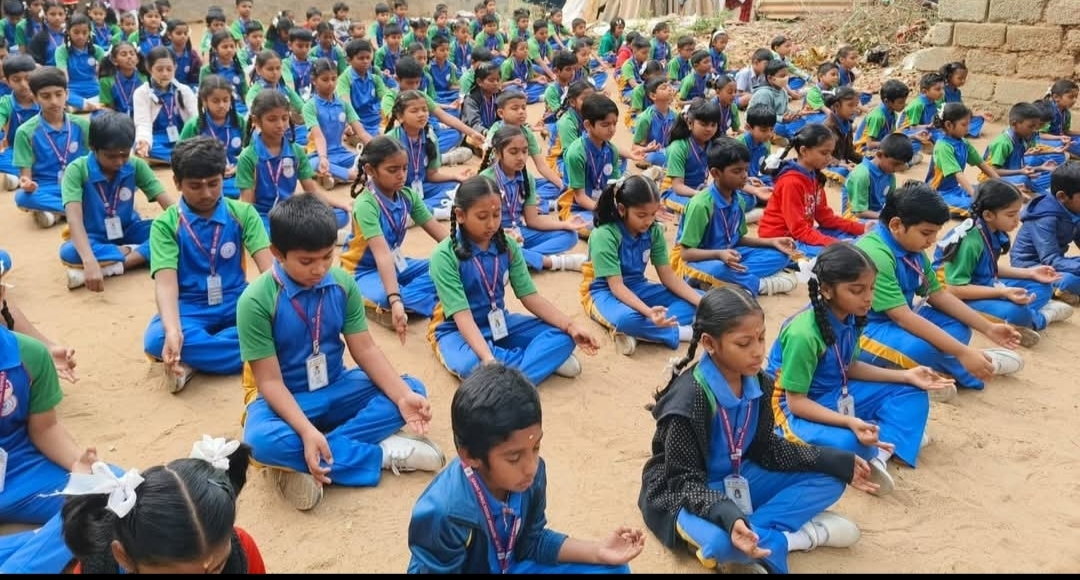 Large group of students seated in meditation outdoors